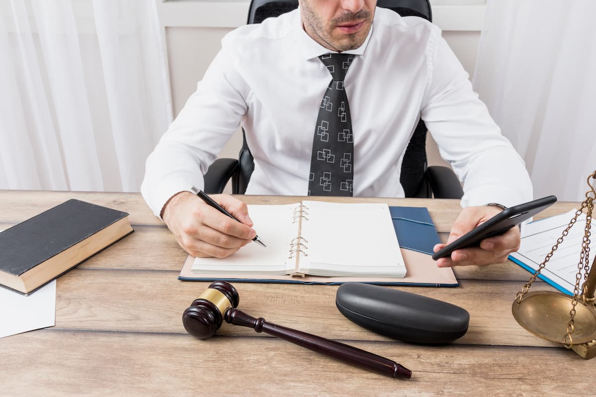 Advogado analisando documentos e calculadora, representando questões legais sobre pagamento de precatórios.