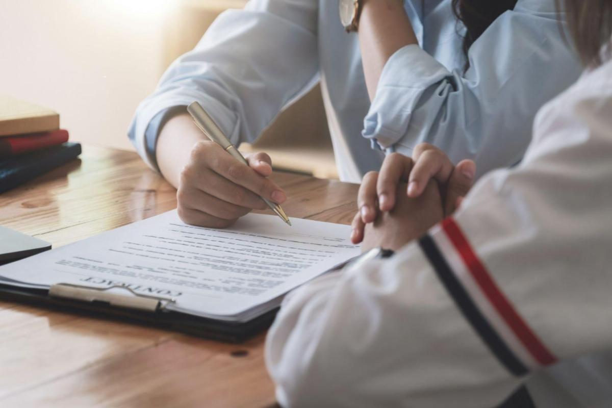 Pessoa analisando contrato sobre investimentos com foco em precatórios ou renda fixa, em ambiente de escritório.