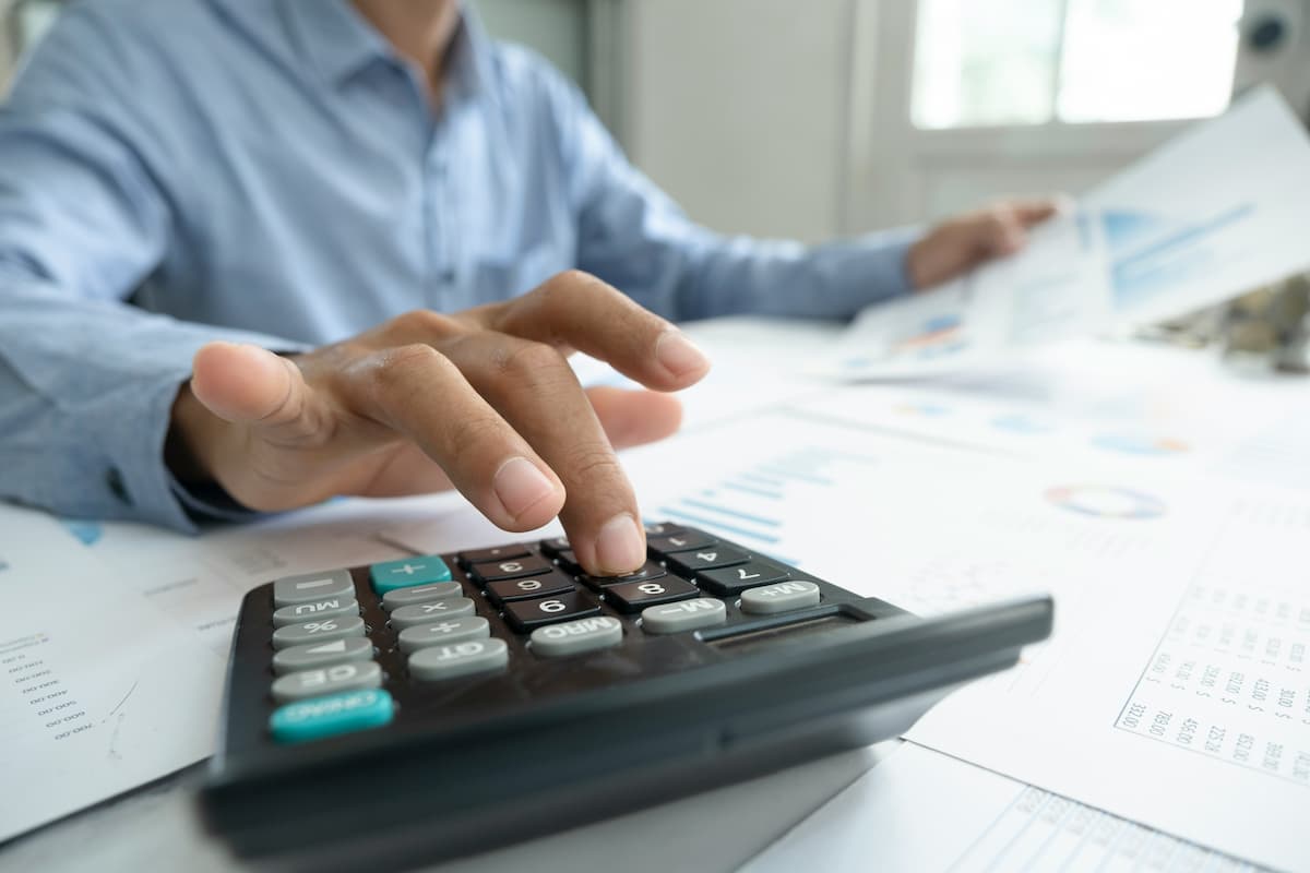 Pessoa usando a calculadora do milhão da Hurst Capital para analisar gráficos e planejar investimentos financeiros.
