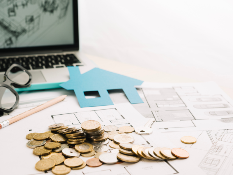 Descrição da Imagem A imagem é um close-up com foco em elementos que simbolizam investimento, planejamento e o mercado imobiliário.