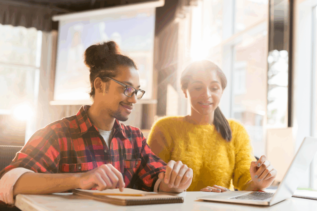 Duas pessoas em discussão analisando relatórios e dados financeiros, representando a due diligence em ativos judiciais.